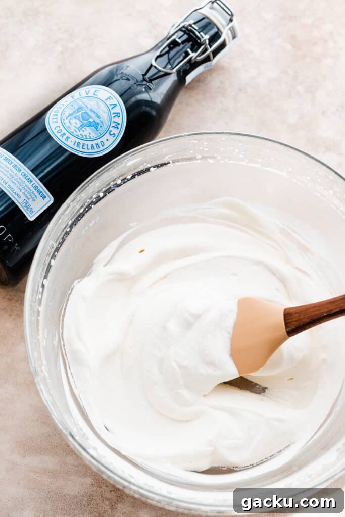 Irish Cream Pumpkin Cheesecake Bars Recipe for Fall Desserts 7 A bowl of boozy whipped cream with a bottle of five farms.
