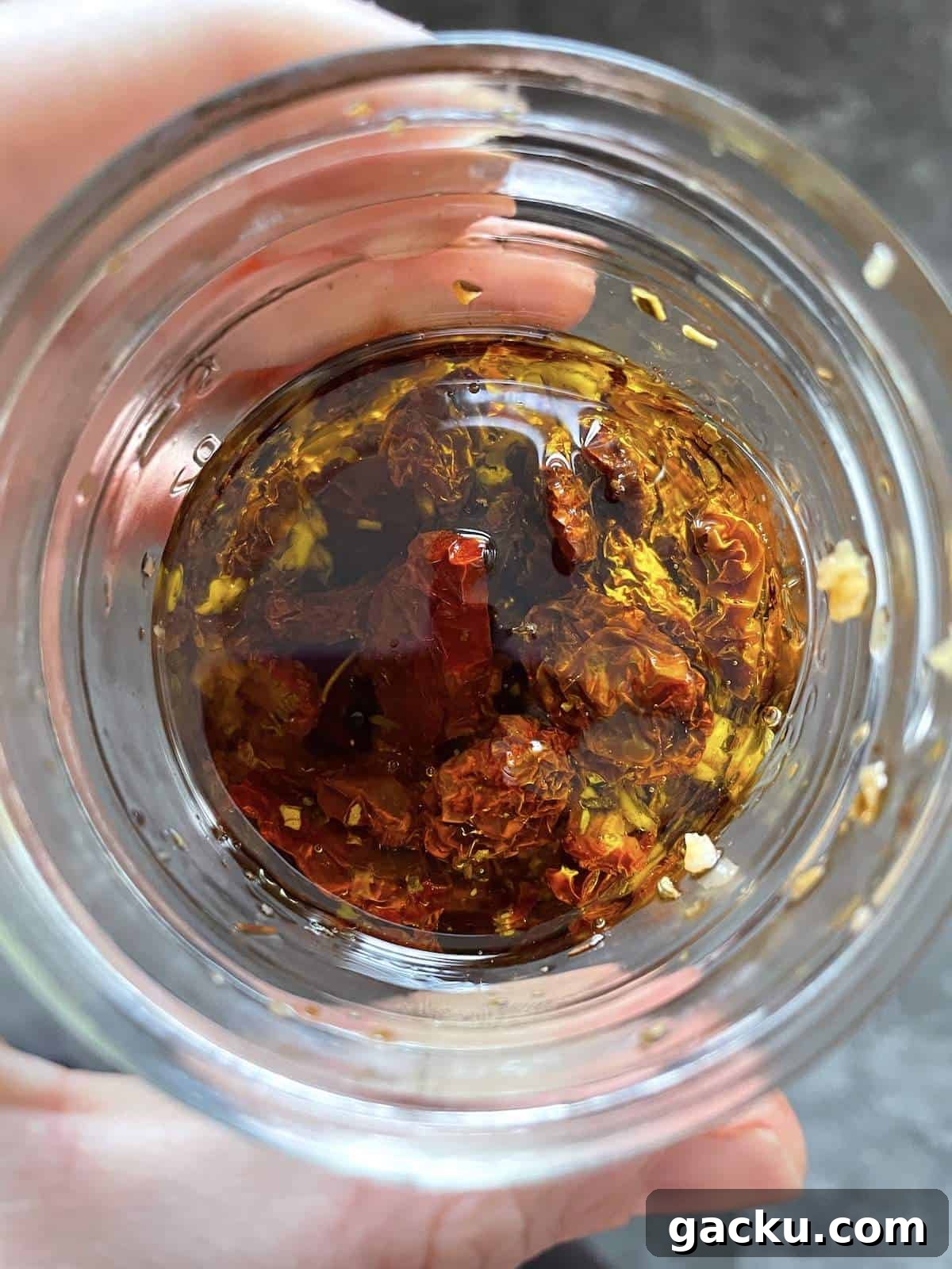 Dehydrating Cherry Tomatoes: Step-by-Step Guide for Perfect Results 11 A small jar of sun-dried cherry tomatoes and garlic in olive oil.