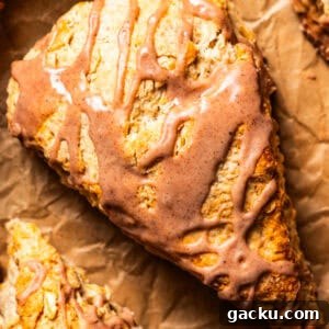 Buttery Cinnamon Scones Recipe for Flaky, Tender Bites 2 Overhead close-up of a glazed cinnamon scone set on a sheet of brown paper.