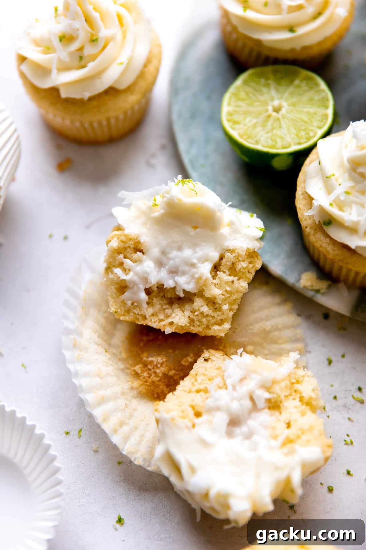Coconut Lime Cupcakes with Creamy Coconut Frosting 8 Sliced open coconut lime cupcake showing creamy coconut filling in the middle.