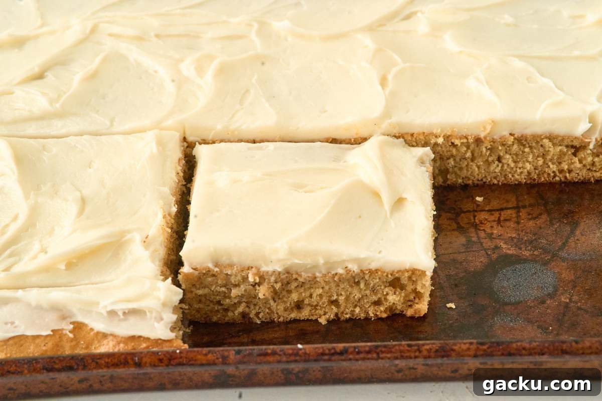 Moist Spiced Sourdough Banana Cake Recipe for Tangy Flavor 9 Banana cake cut into squares and frosted with cream cheese icing in baking pan.