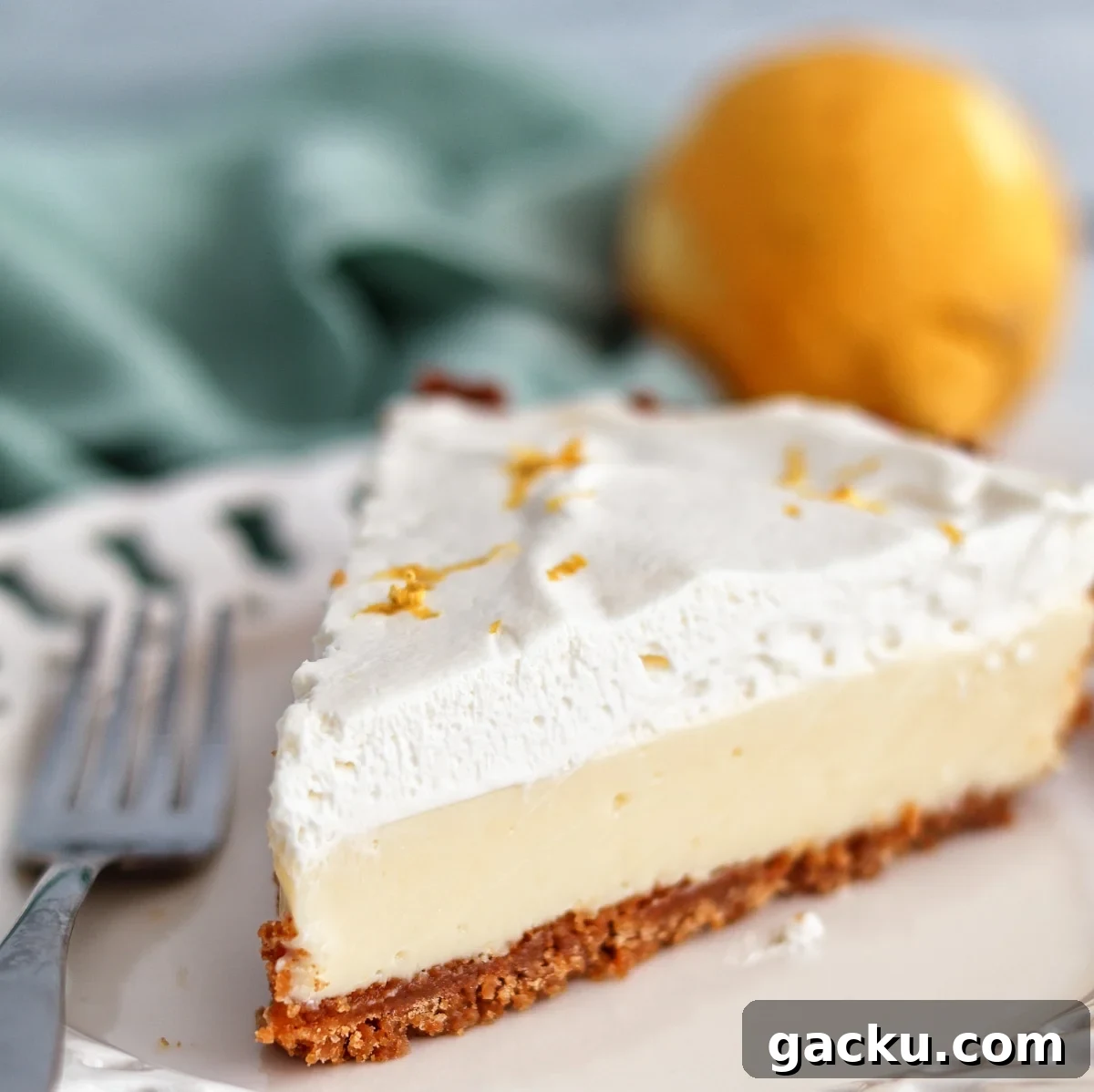 Gluten-Free Lemon Pie Recipe: Zesty Tart with Buttery Crust 2 gluten free lemon pie on white scalloped plate with lemon and light green towel in the background.