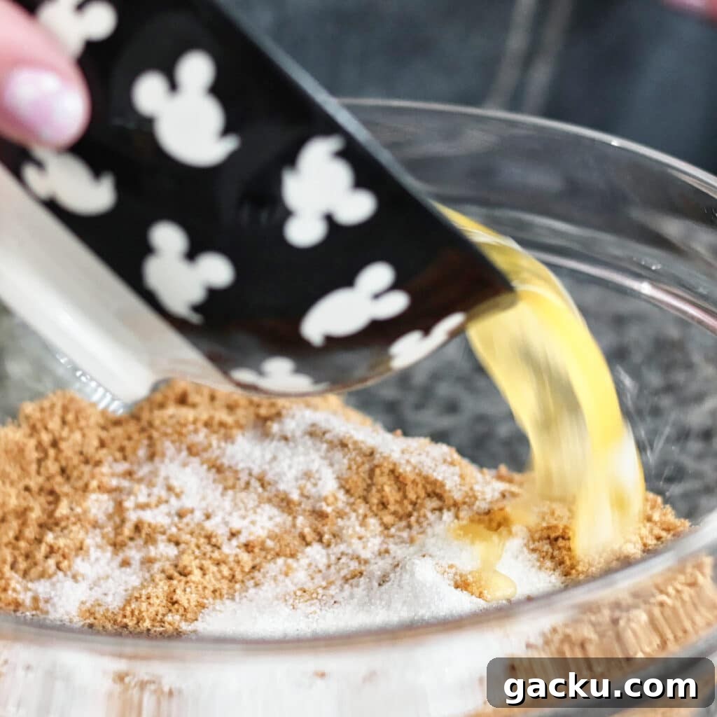 Gluten-Free Lemon Pie Recipe: Zesty Tart with Buttery Crust 5 pouring melted butter into graham cracker crumbs and sugar in bowl.