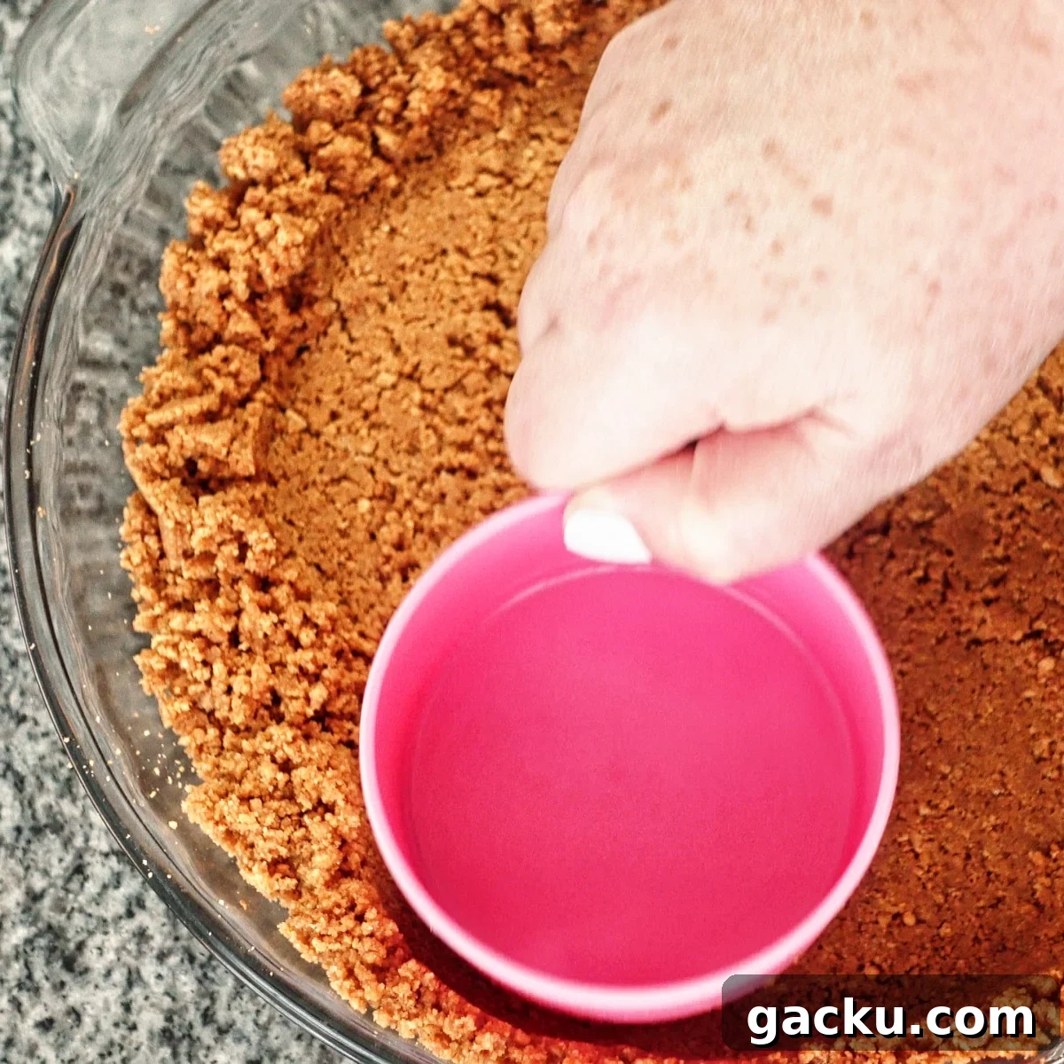 Gluten-Free Lemon Pie Recipe: Zesty Tart with Buttery Crust 7 pressing crust into glass pie plate with pink measuring cup.