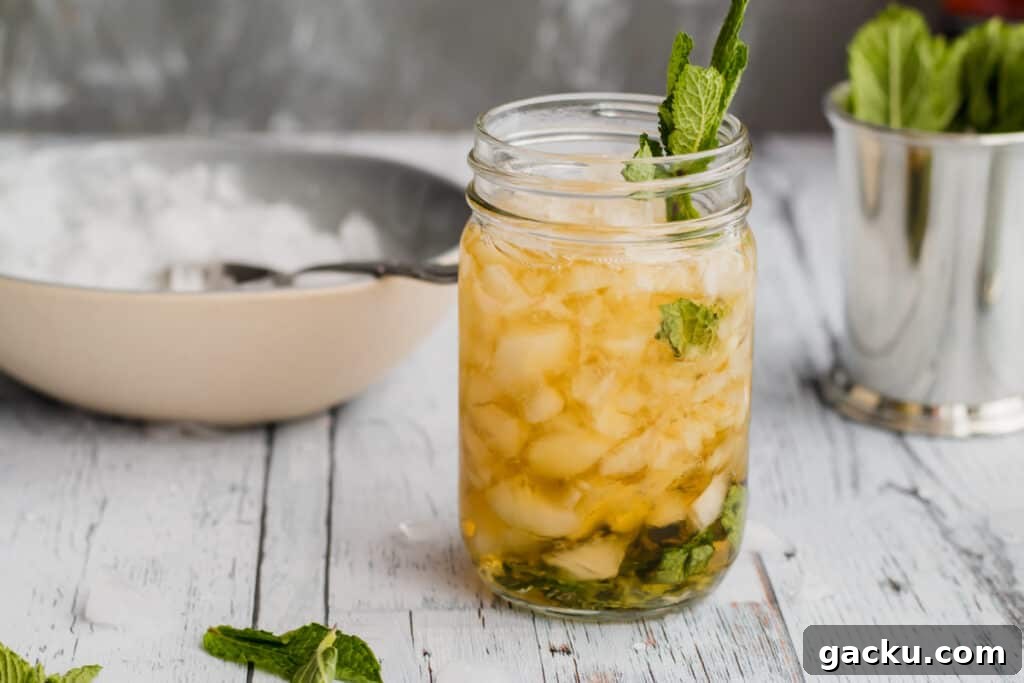Classic Mint Julep Recipe: How to Make the Southern Cocktail 2 mint julep in mason jar with crushed ice in a bowl