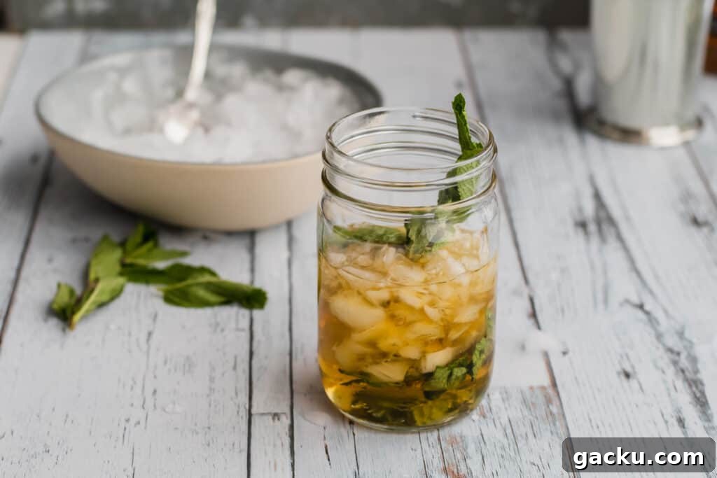 Classic Mint Julep Recipe: How to Make the Southern Cocktail 5 crushed ice being added to a mint julep