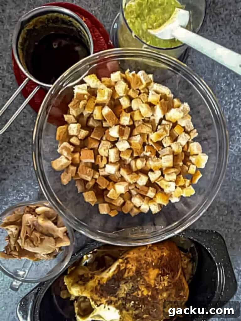 Amish Roast Chicken and Stuffing Casserole Recipe 2 bread cubes in bowl, chopped veggies in chopper bowl, browned butter in saucepan, and cooked chicken in roaster.