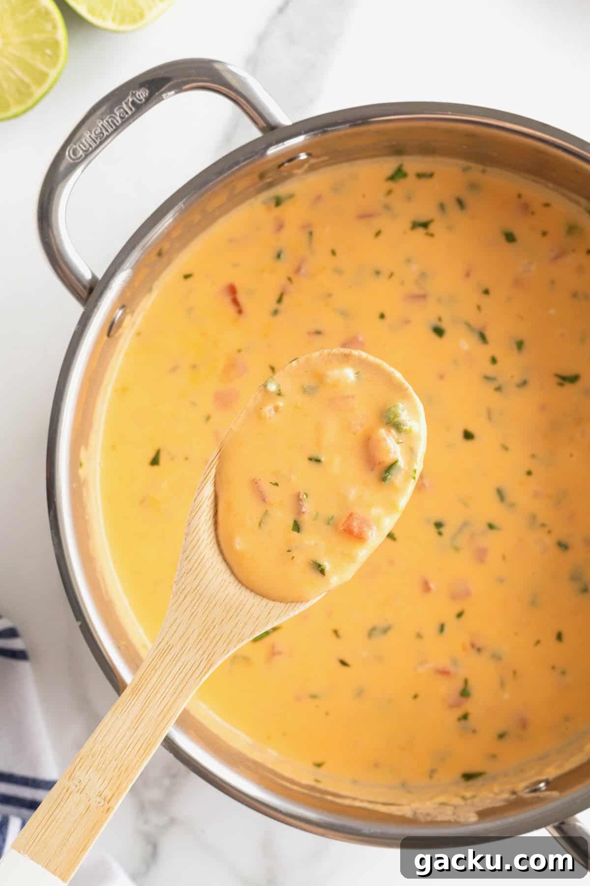 Stovetop Queso Recipe: Creamy, Quick Melted Cheese Dip 4 A large stainless steel pot of queso dip. A wooden spoon full of queso hovers over the top.