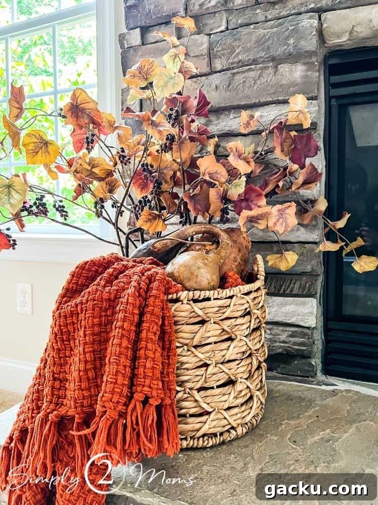 15 Fall DIY Home Decor Crafts to Transform Your Space 16 completed basket filled with blanket, gourds and fall leaf and berry stems