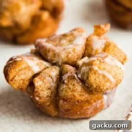 White Chocolate Raspberry Muffins with Fresh Raspberries 8 close up shot of Monkey Bread Muffins topped with glaze on plate