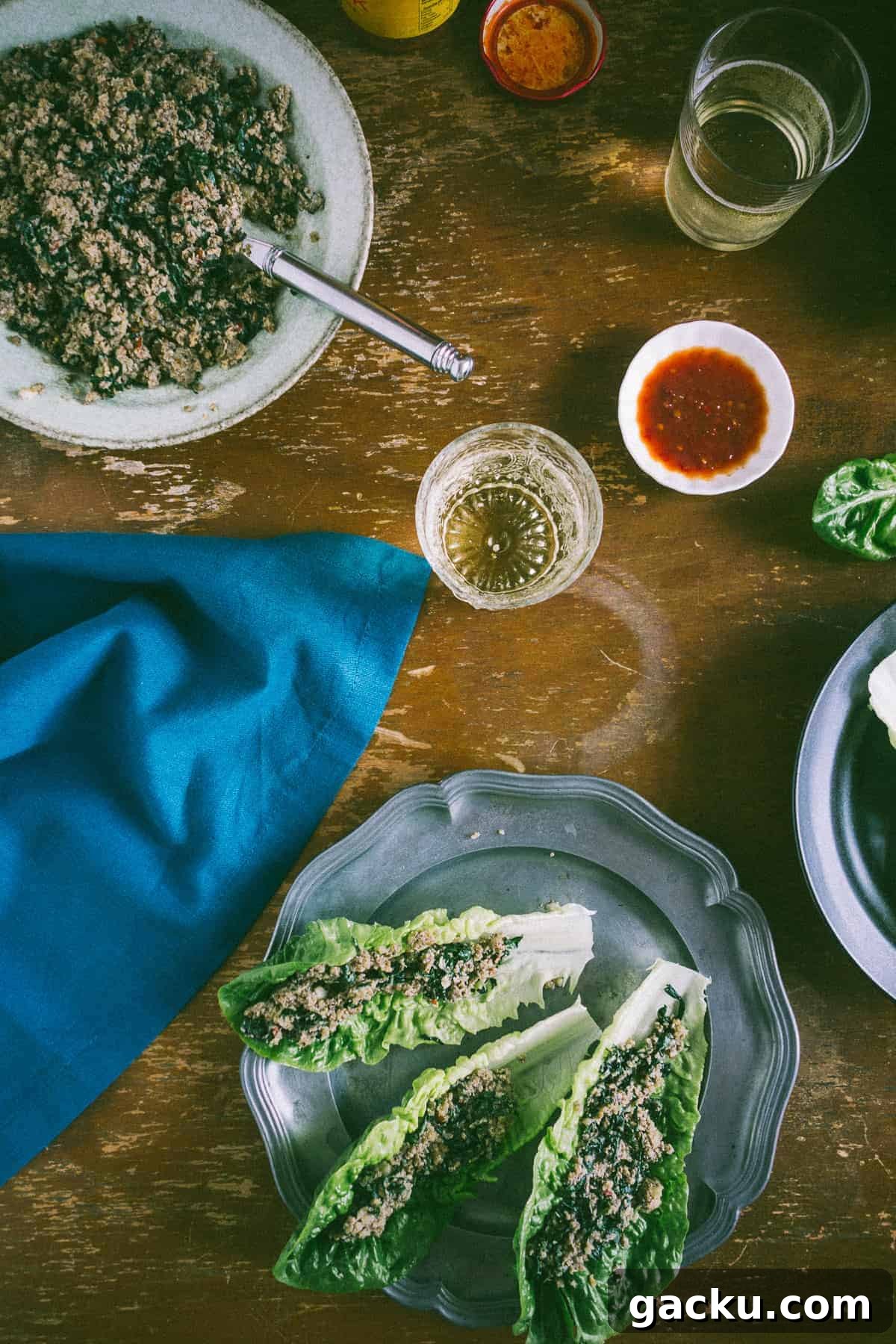 cooked mushrooms on a plate with another plate next to it filled with lettuce leaves stuffed with cooked mushrooms