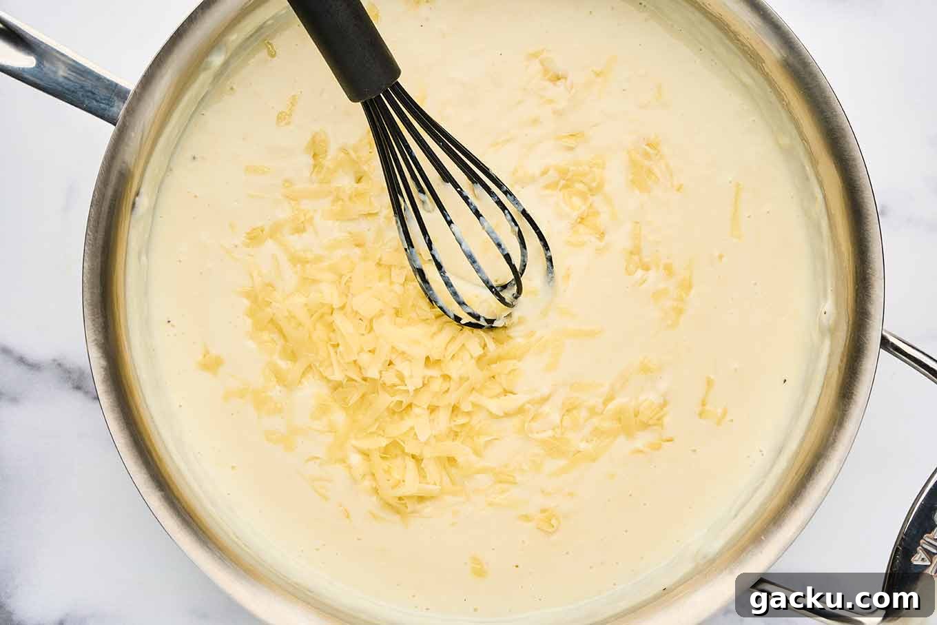 Herbed French Macaroni & Cheese with Ham 5 Grated French cheeses being added to béchamel sauce for French macaroni and cheese.