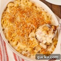 Herbed French Macaroni & Cheese with Ham 7 French macaroni and cheese casserole with crisp panko topping and creamy cheese sauce being served from baking dish.