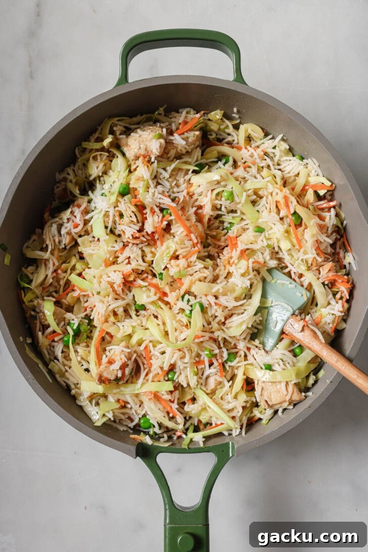 Indo-Chinese Basmati Fried Rice Recipe 12 Indo-Chinese Chicken Fried Rice in a pan with a rubber spatula.