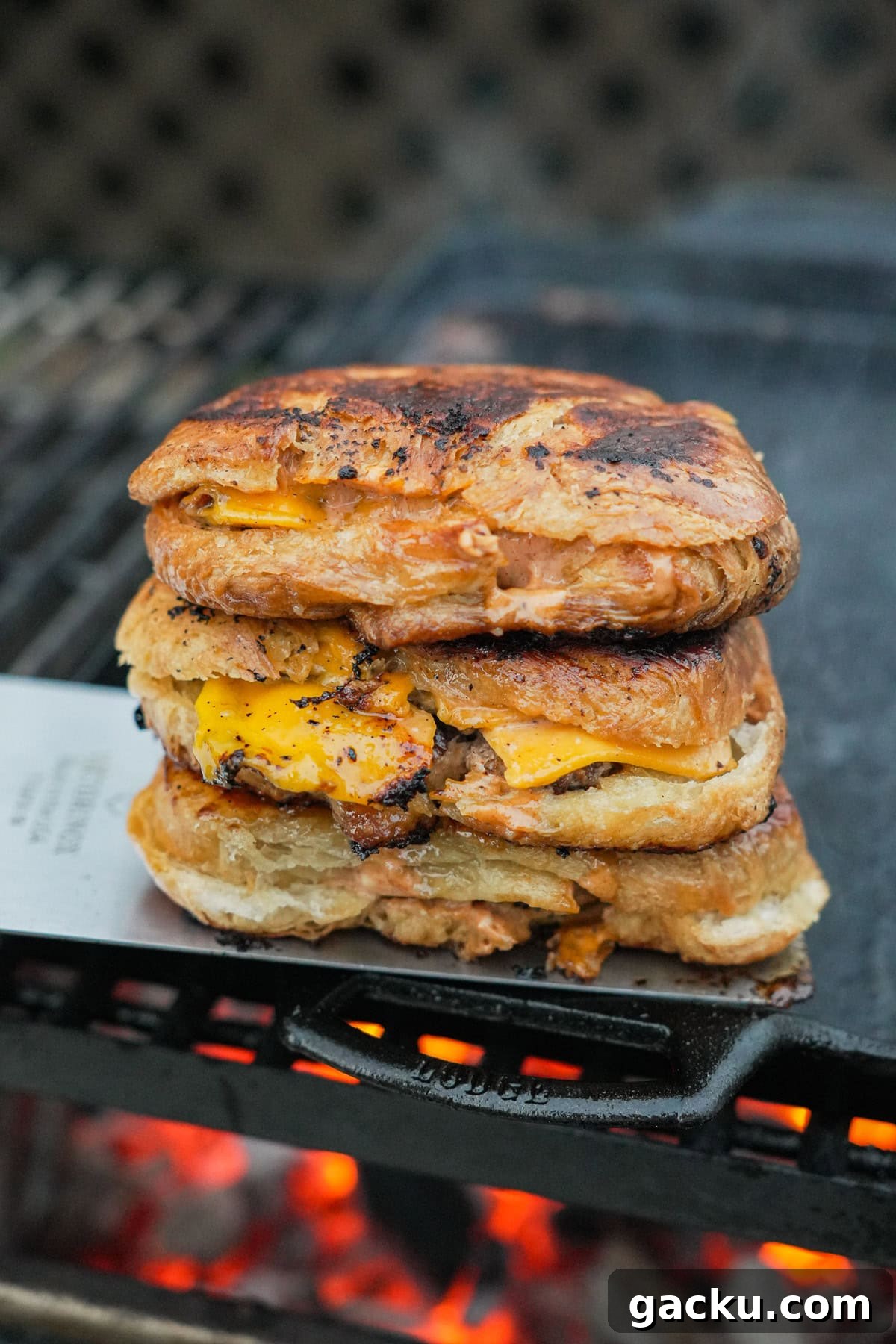 Croissant Smash Burger Recipe: Crispy-Buttery Smash Burger Guide 2 A stack of croissant three smashburgers on a cast iron skillet over the grill