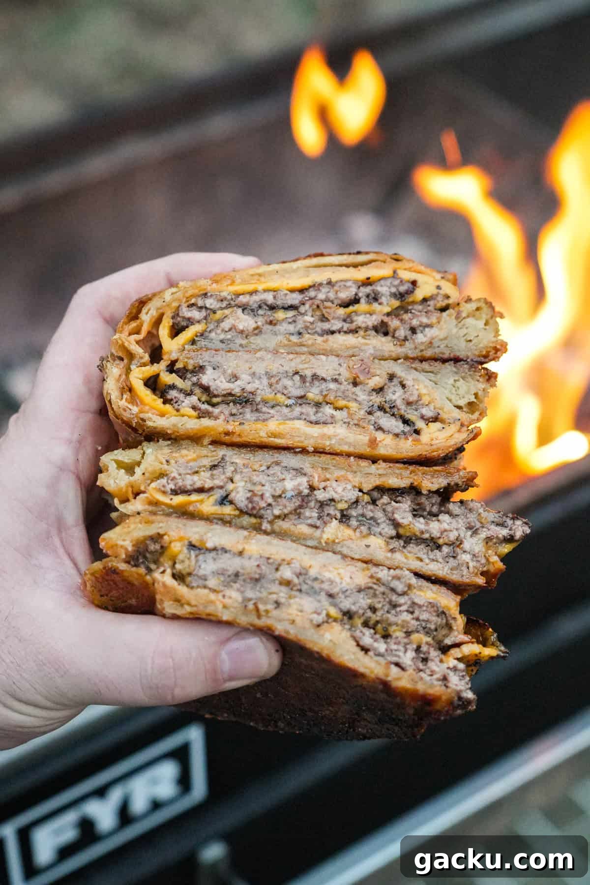 Croissant Smash Burger Recipe: Crispy-Buttery Smash Burger Guide 3 Two sliced croissant smashburgers with cheese, burger sauce and garlic butter with the grill fire in the background