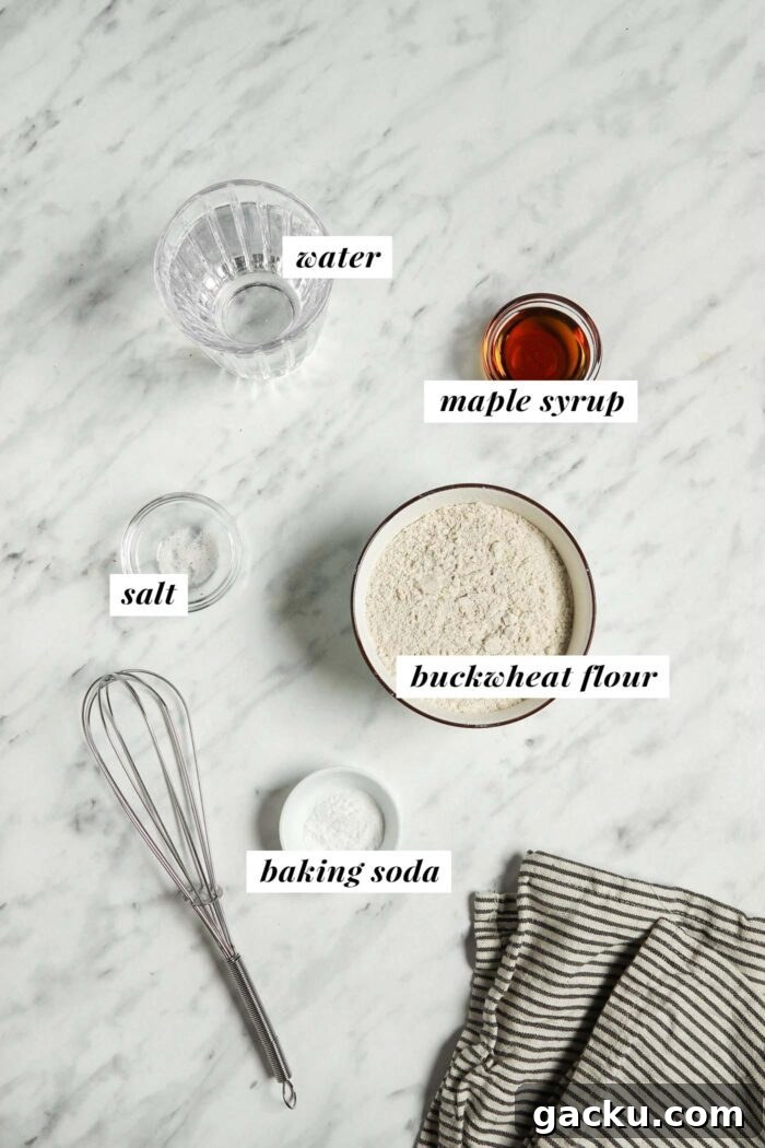Water, maple syrup, buckwheat flour, salt and baking soda in small bowls. Each ingredient is labelled with a text graphic.