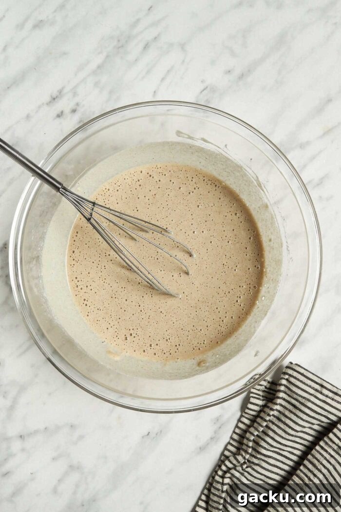 Buckwheat crepe batter in mixing bowl with a whisk.
