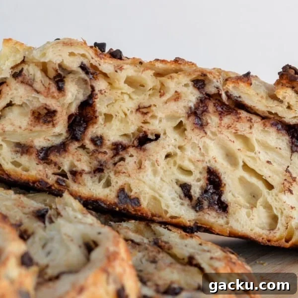 Chocolate chip sourdough bread loaf cut in half on a cutting board.