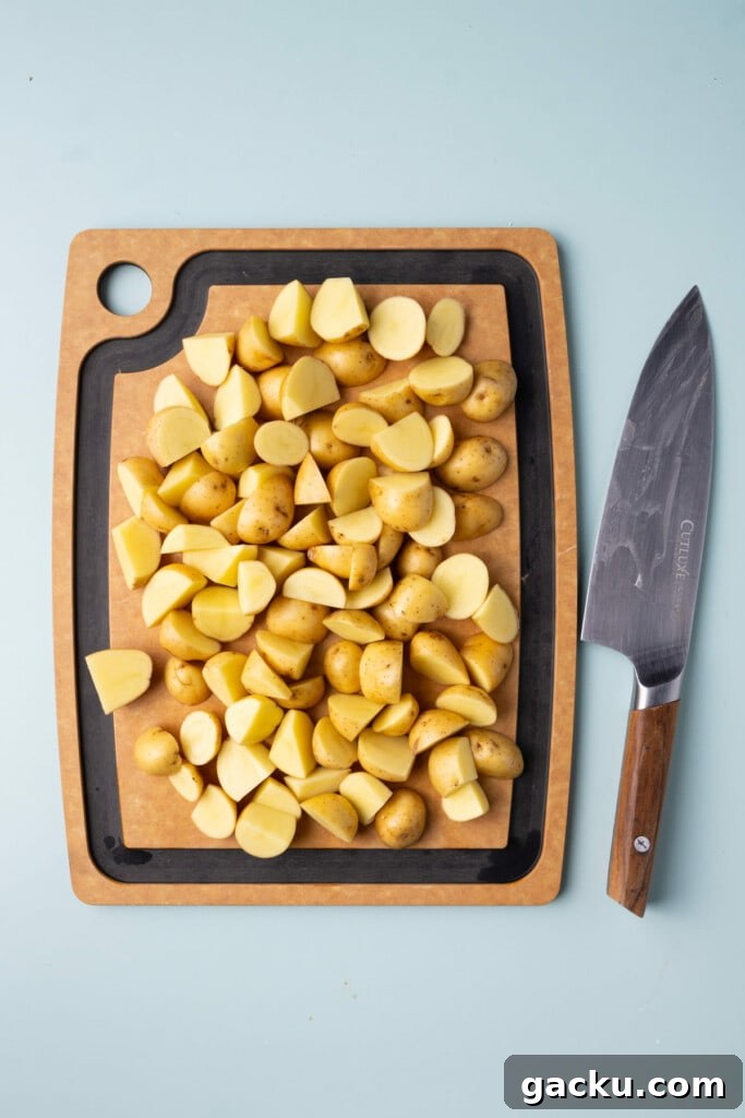 30-Minute Roasted Baby Potatoes & Broccoli with Garlic Butter 5 Honey gold potatoes on a chopping board cut into bite-sized wedges.