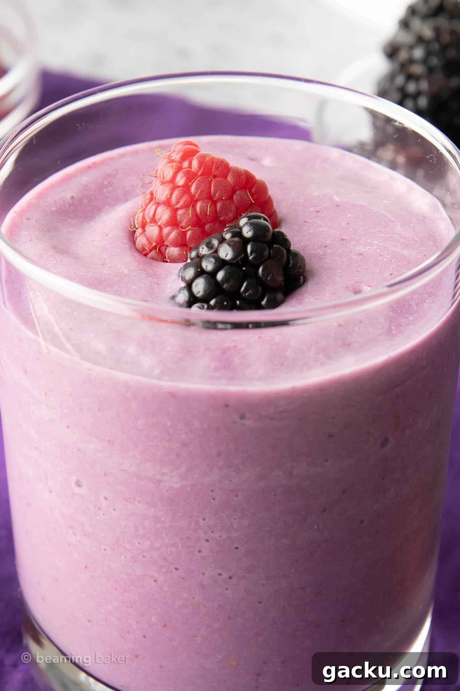 Tight shot of keto mixed berry smoothie with a raspberry and a blackberry garnish on top