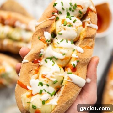 overhead shot of hand holding meatball sub above garnish and ingredients