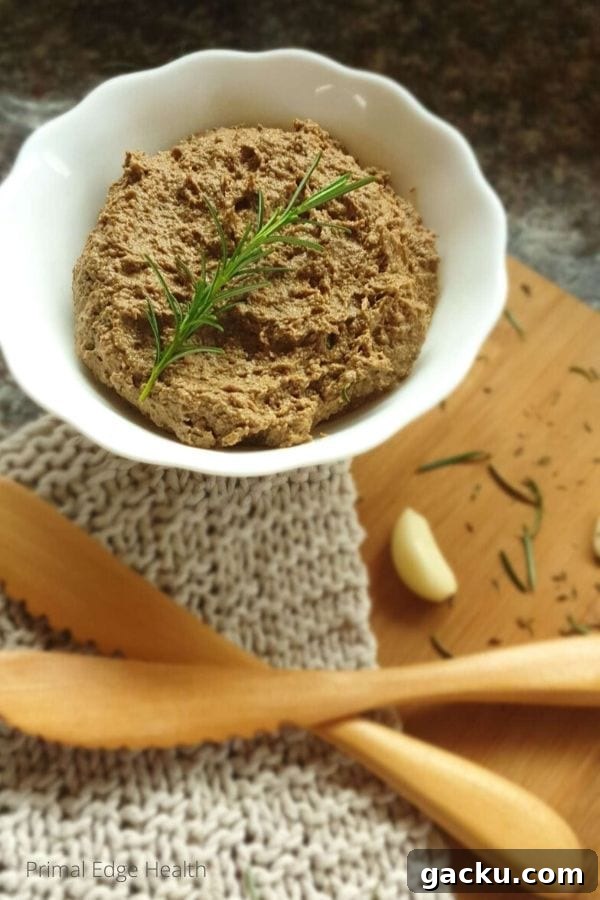 A white bowl with dairy-free liver pate on a wooden board.