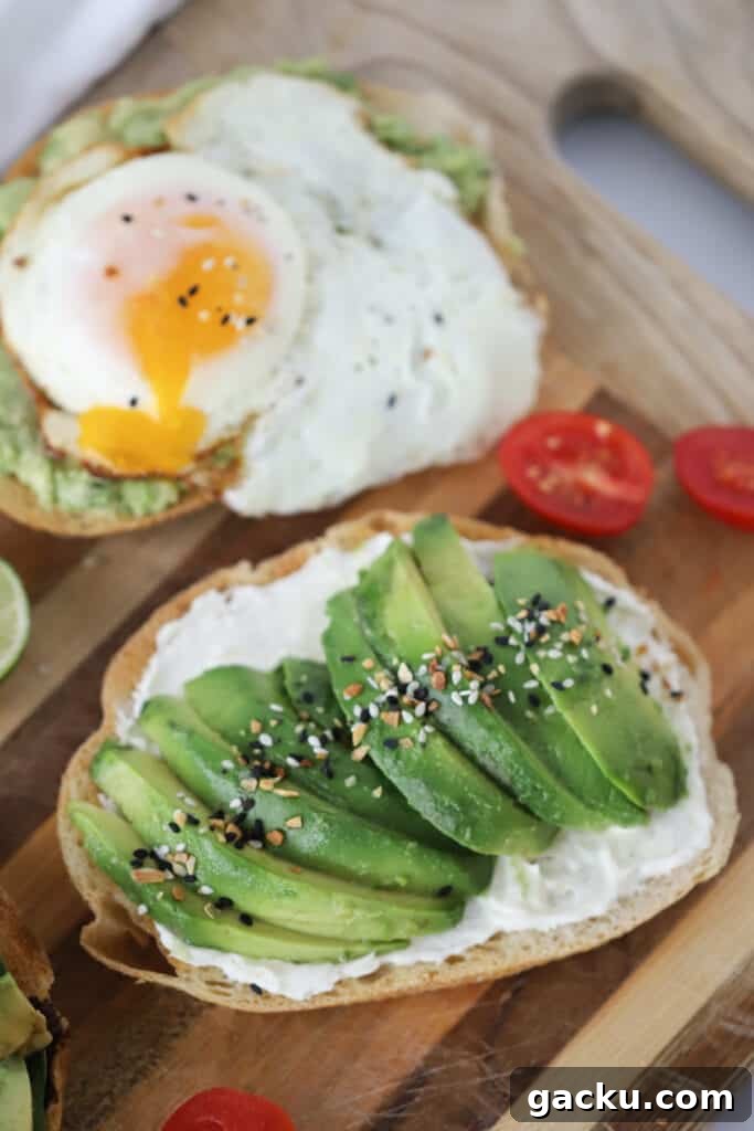 A cutting board with toast topped with sliced avocados and seasoning.