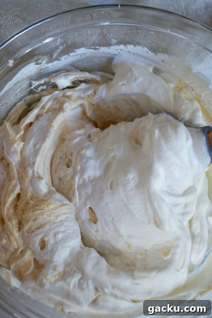 Mini Peanut Butter Espresso No-Bake Cheesecakes 16 whipped cream being folded into peanut butter mixture with a spatula