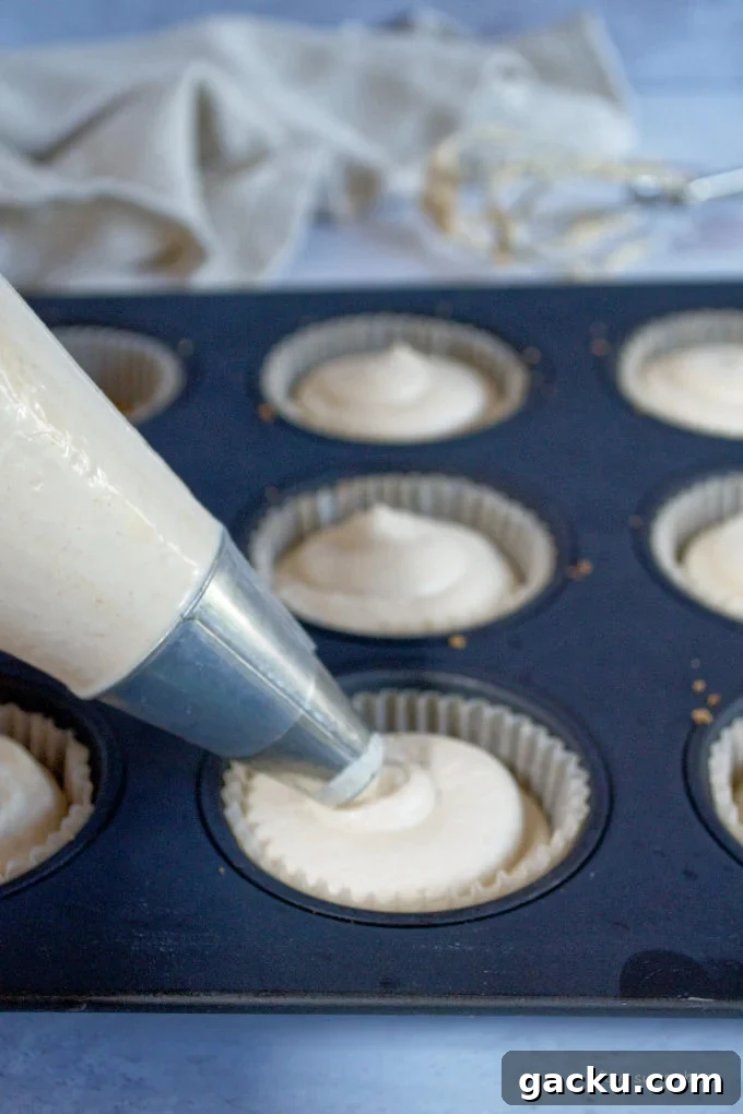 Mini Peanut Butter Espresso No-Bake Cheesecakes 18 piping bag filling espresso crust with peanut butter cheesecake filling