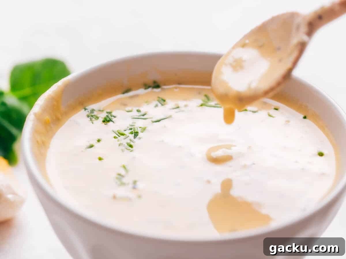 Lemon tahini dressing with a spoon.