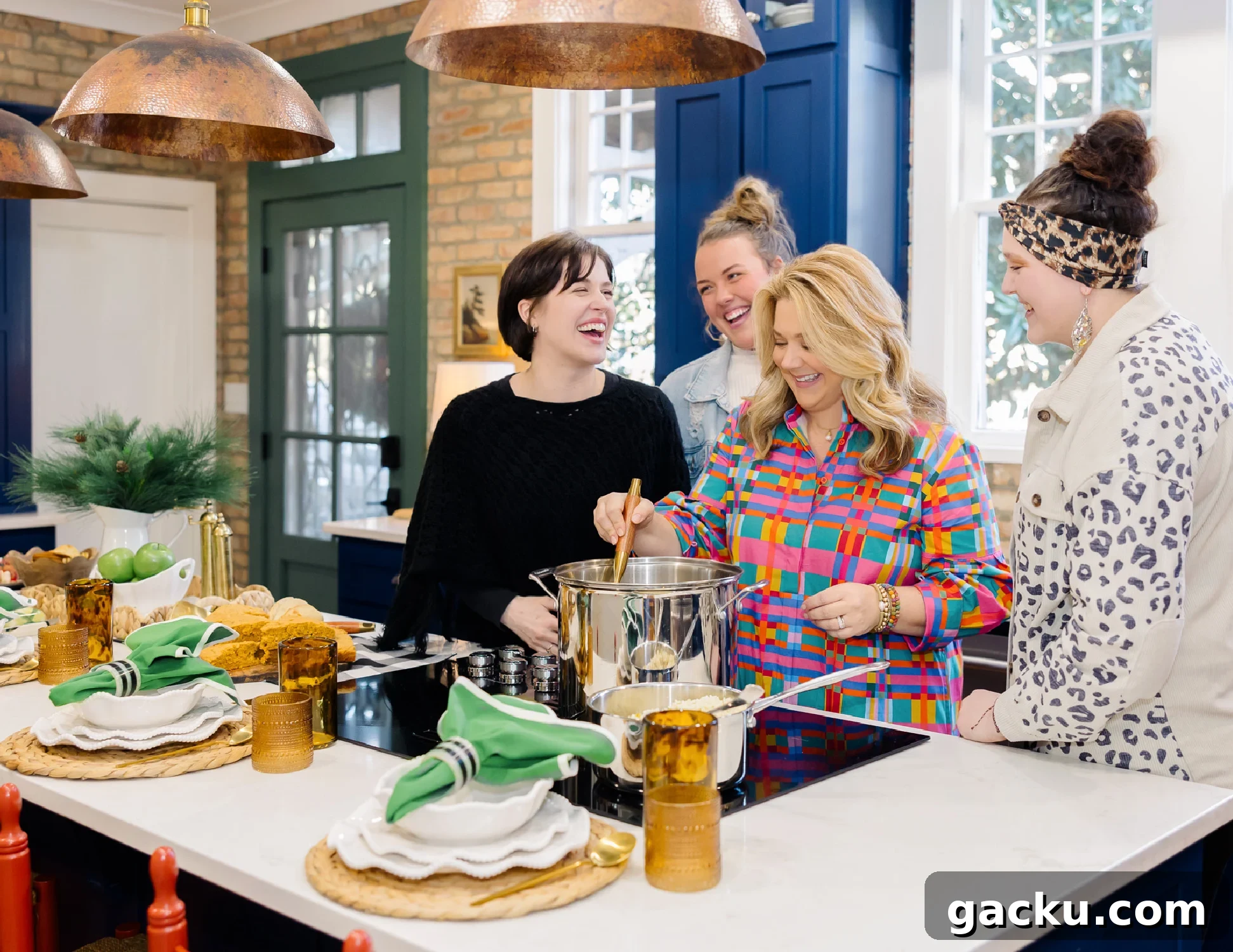 Group photo of 4 friends gathered around a pot of gumbo in the kitchen, laughing and cooking.