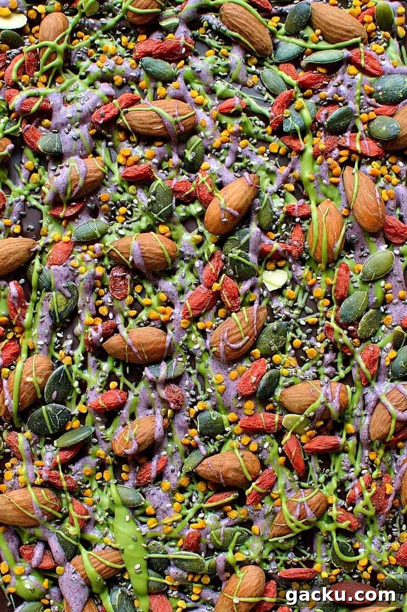 Superfood Chocolate Bark Recipe with Nuts & Seeds 3 Superfood chocolate bark - dark chocolate topped with almonds, goji berries, seeds, bee pollen and white chocolate flavoured with matcha and freeze dried blueberry powder
