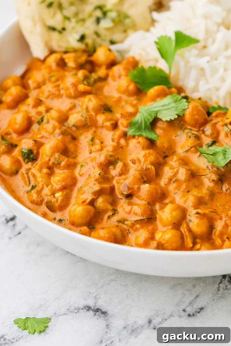 Restaurant-Style Chickpea Tikka Masala Recipe 2 A close up image of chickpea tikka masala served in a bowl with rice.