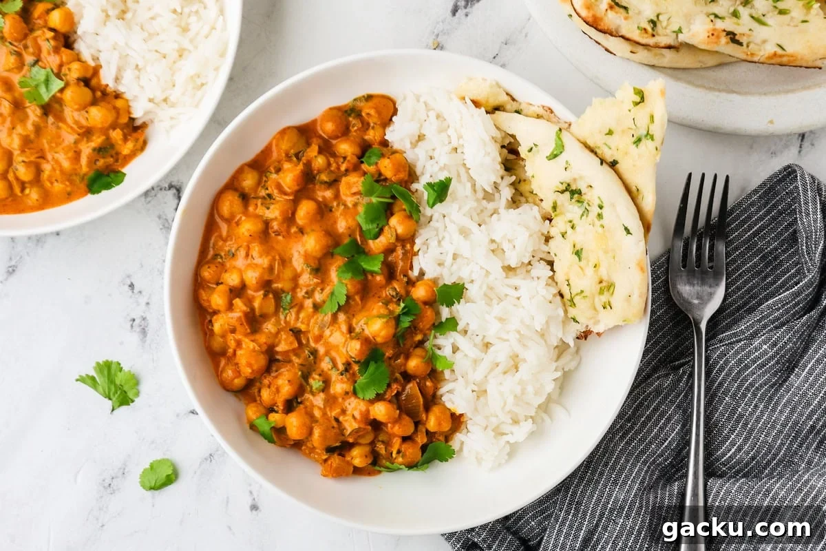 Restaurant-Style Chickpea Tikka Masala Recipe 11 An overhead image of chickpea tikka masala served on a plate with rice and naan.