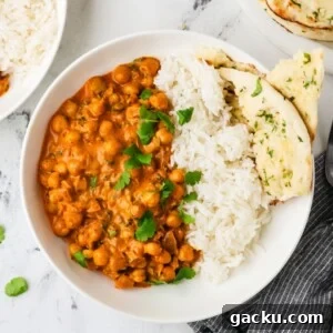 Restaurant-Style Chickpea Tikka Masala Recipe 12 An overhead image of chickpea tikka masala served on a plate with rice and naan.