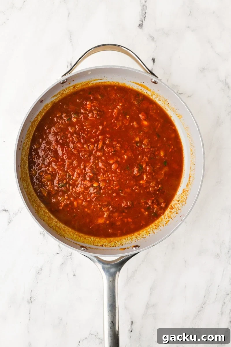 Restaurant-Style Chickpea Tikka Masala Recipe 7 An overhead image of adding tomato paste and stirring to combine.