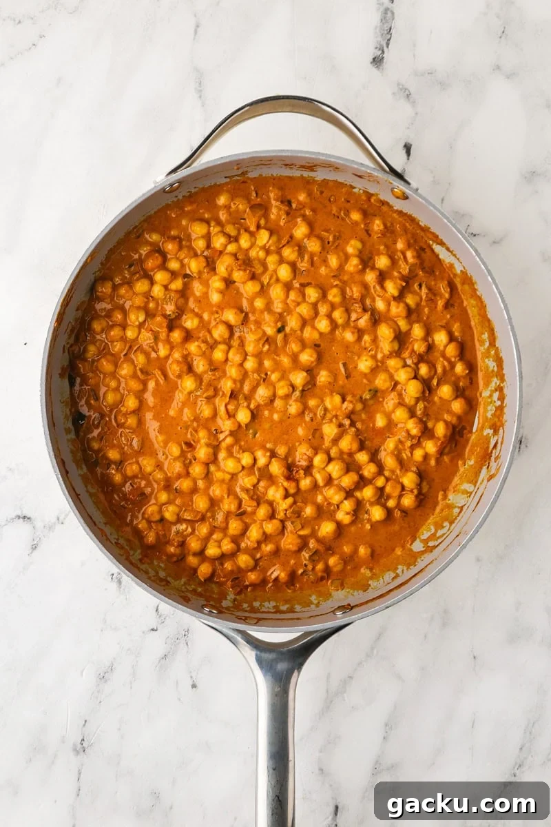 Restaurant-Style Chickpea Tikka Masala Recipe 9 An overhead image of adding chickpeas to the mixture.