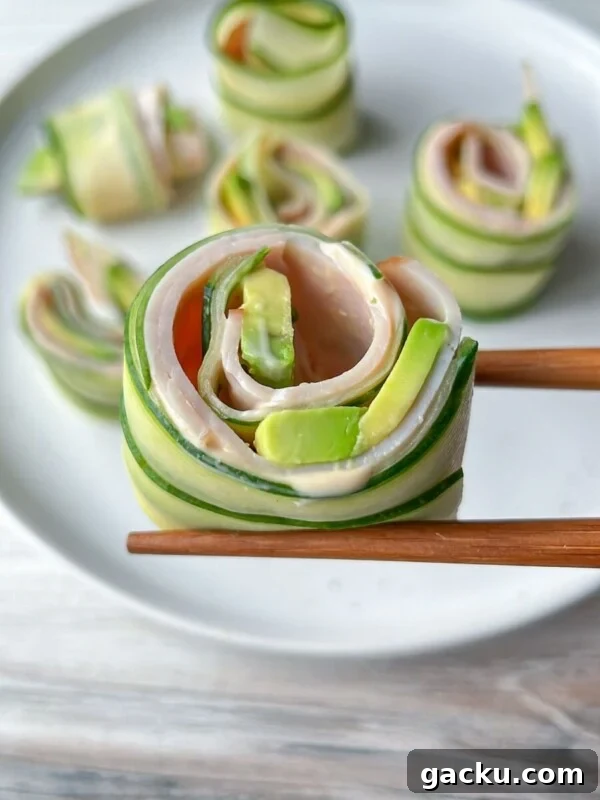 Fluffy Cloud Bread Recipe: Soft, Airy Sandwich Loaf in Minutes 12 Chopsticks hold a Cucumber and Avocado Roll made with ham, while more cucumber and avocado rolls are arranged on a white plate in the background.