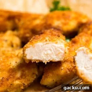 Crispy Pan-Seared Chicken Cutlets with Lemon Garlic Sauce 10 A close up image of a chicken cutlet cut in half revealing the perfectly cooked center.