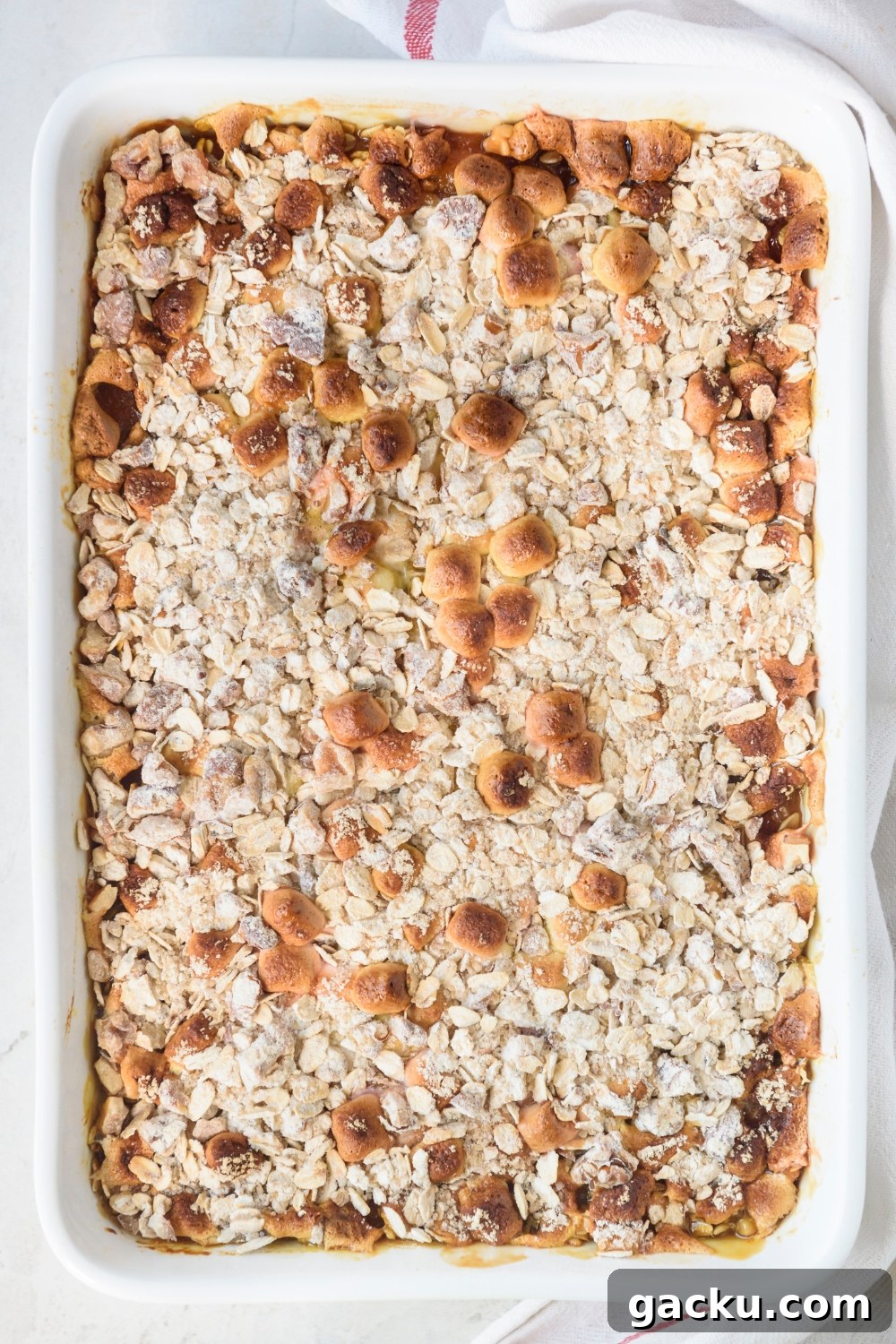 A fully cooked sweet potato casserole in a white casserole dish.