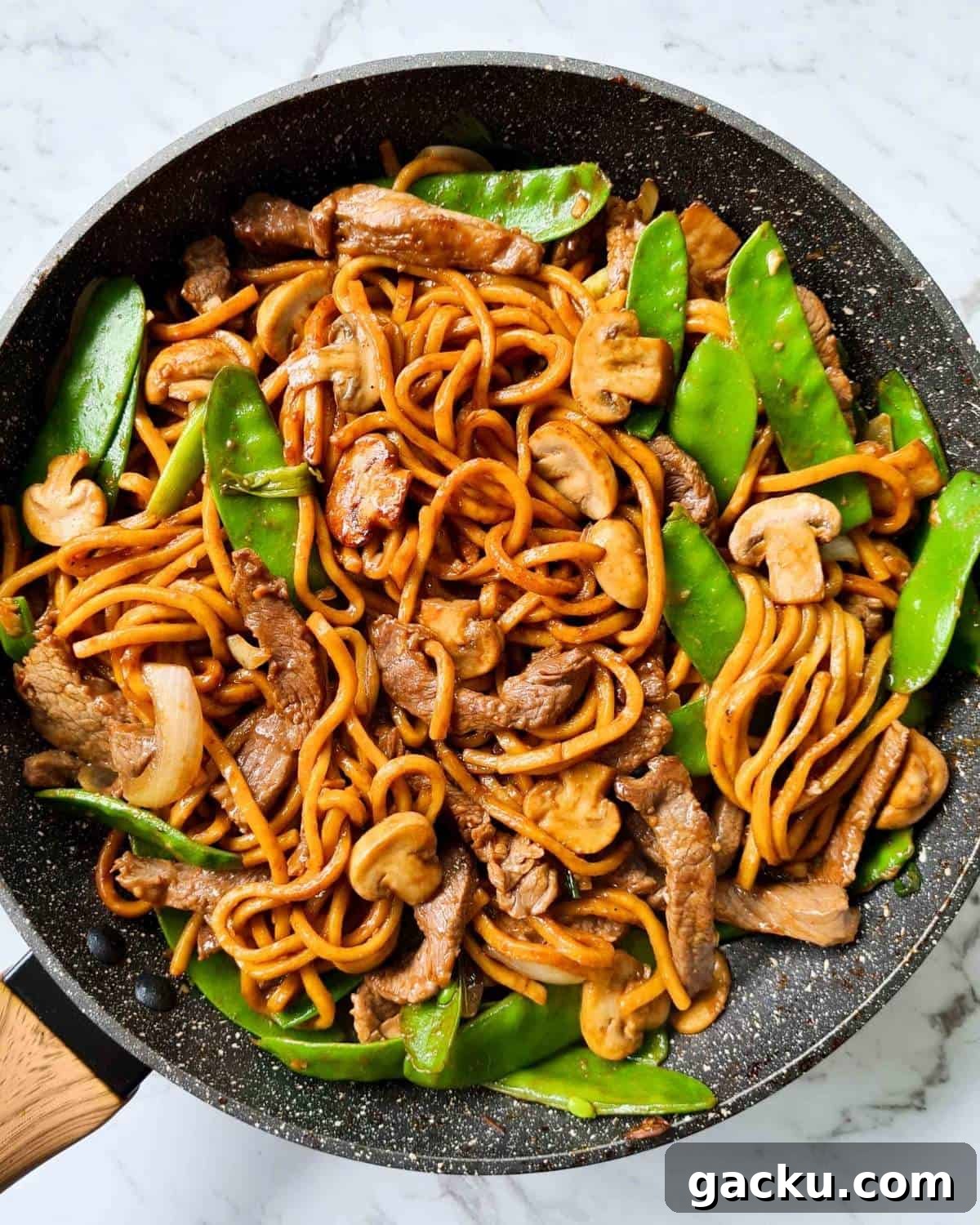 Szechuan Beef Stir-Fry with Noodles: Quick Weeknight Recipe 2 Cooked stir fried noodles in a black pan