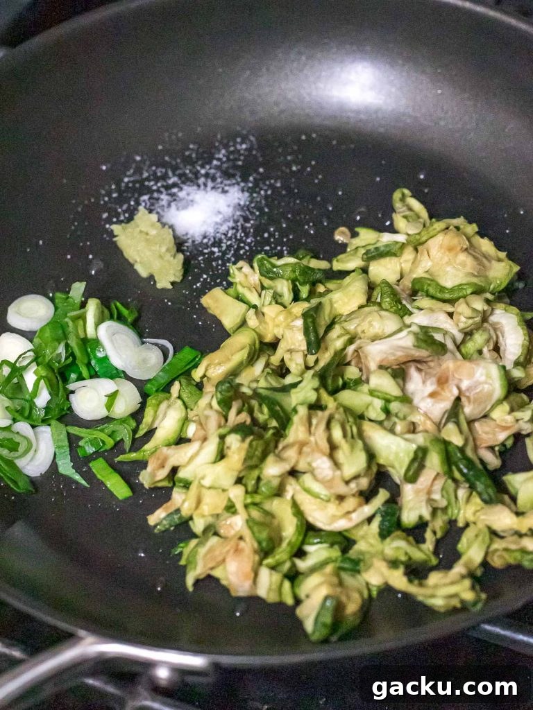 dried zucchini with scallions and garlic in a pan