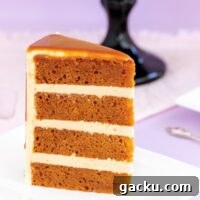 A slice of rich caramel mud cake with dripping caramel sauce on a white plate with a purple background.