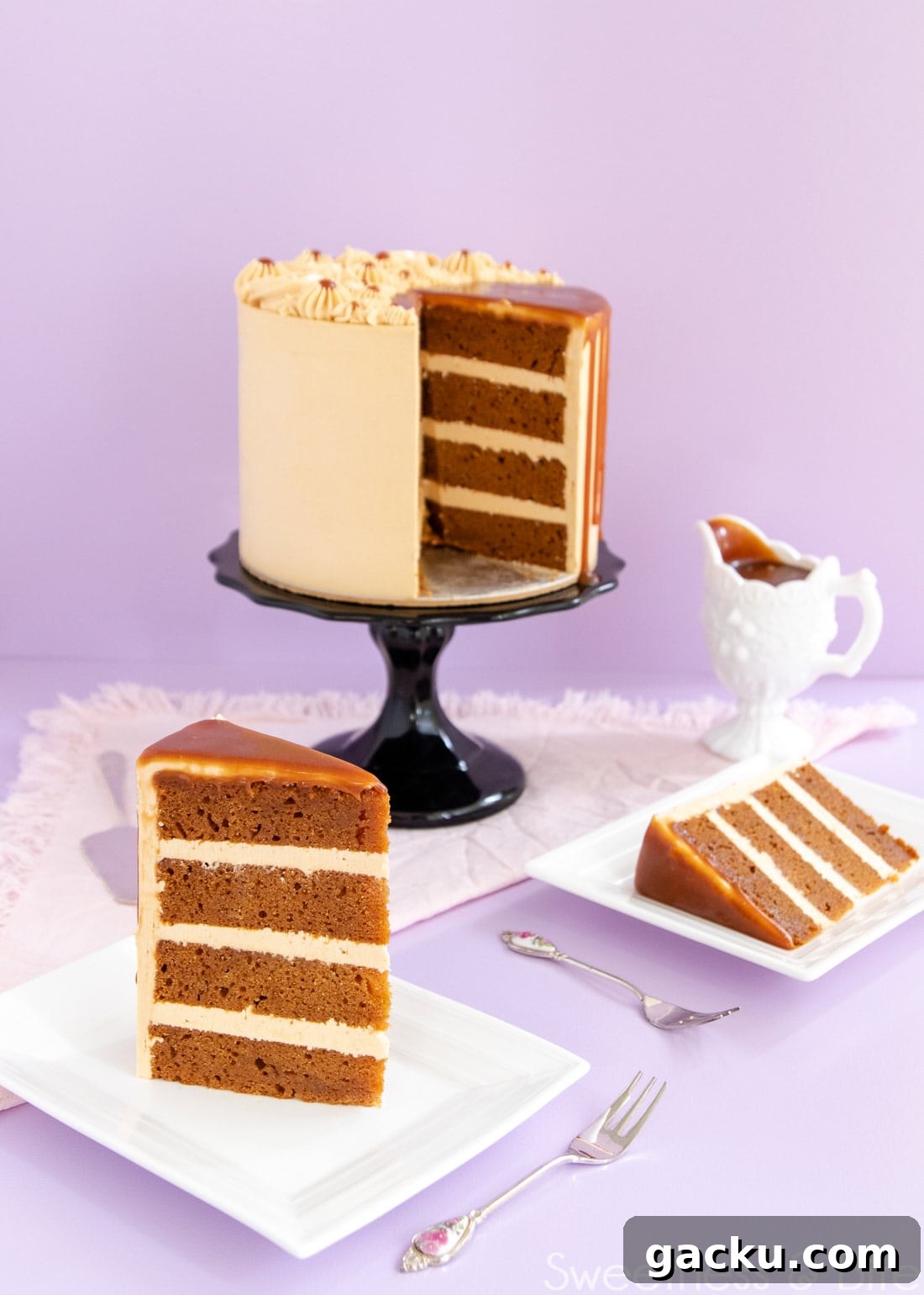 Slice of cake showing the layers of cake and caramel buttercream. Cake on the cake stand in the background.