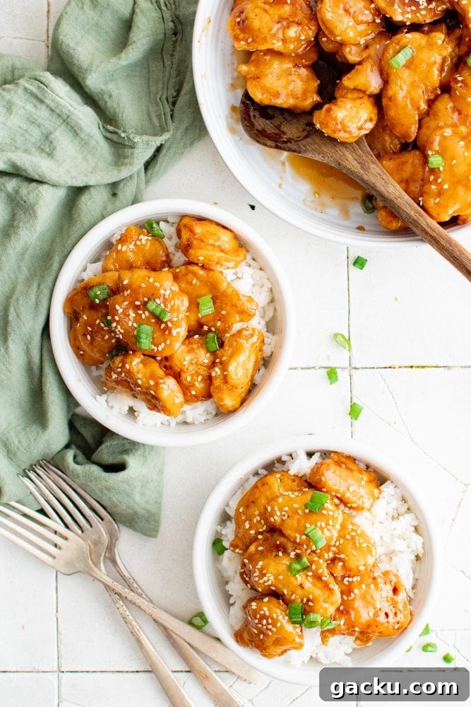 picture of sesame chicken in a bowl over rice