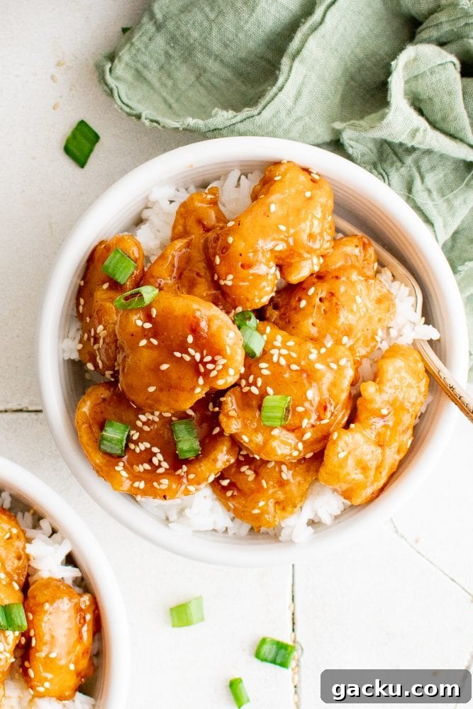 picture of sesame chicken in a bowl over rice