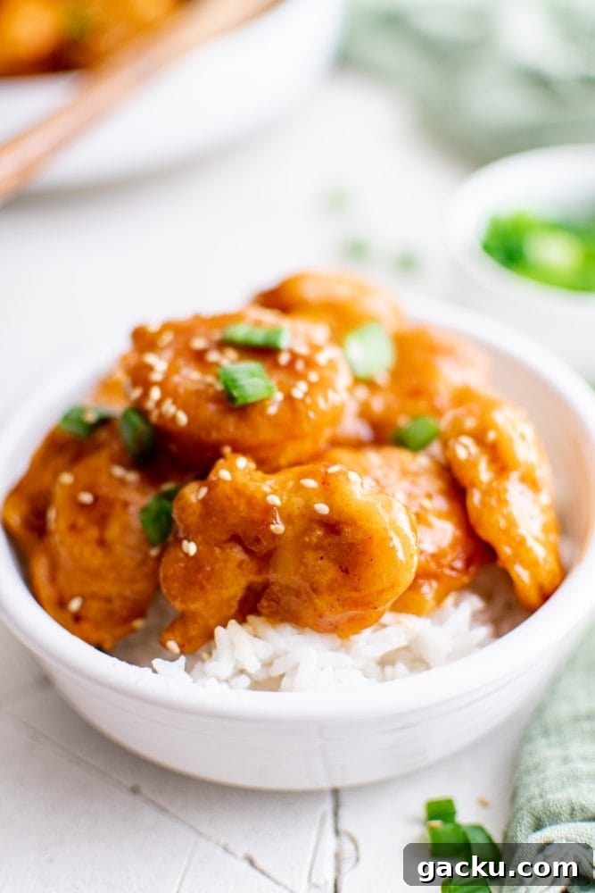 picture of sesame chicken in a bowl over rice
