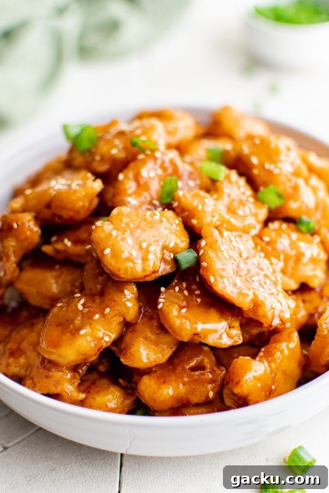 picture of sesame chicken in a bowl over rice