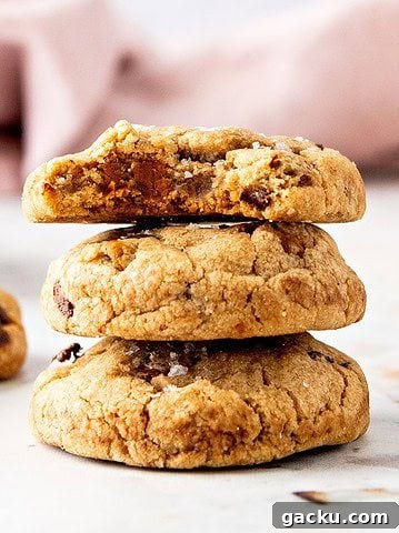 Stack of biscoff chocolate chip cookies. White surface, pink background.